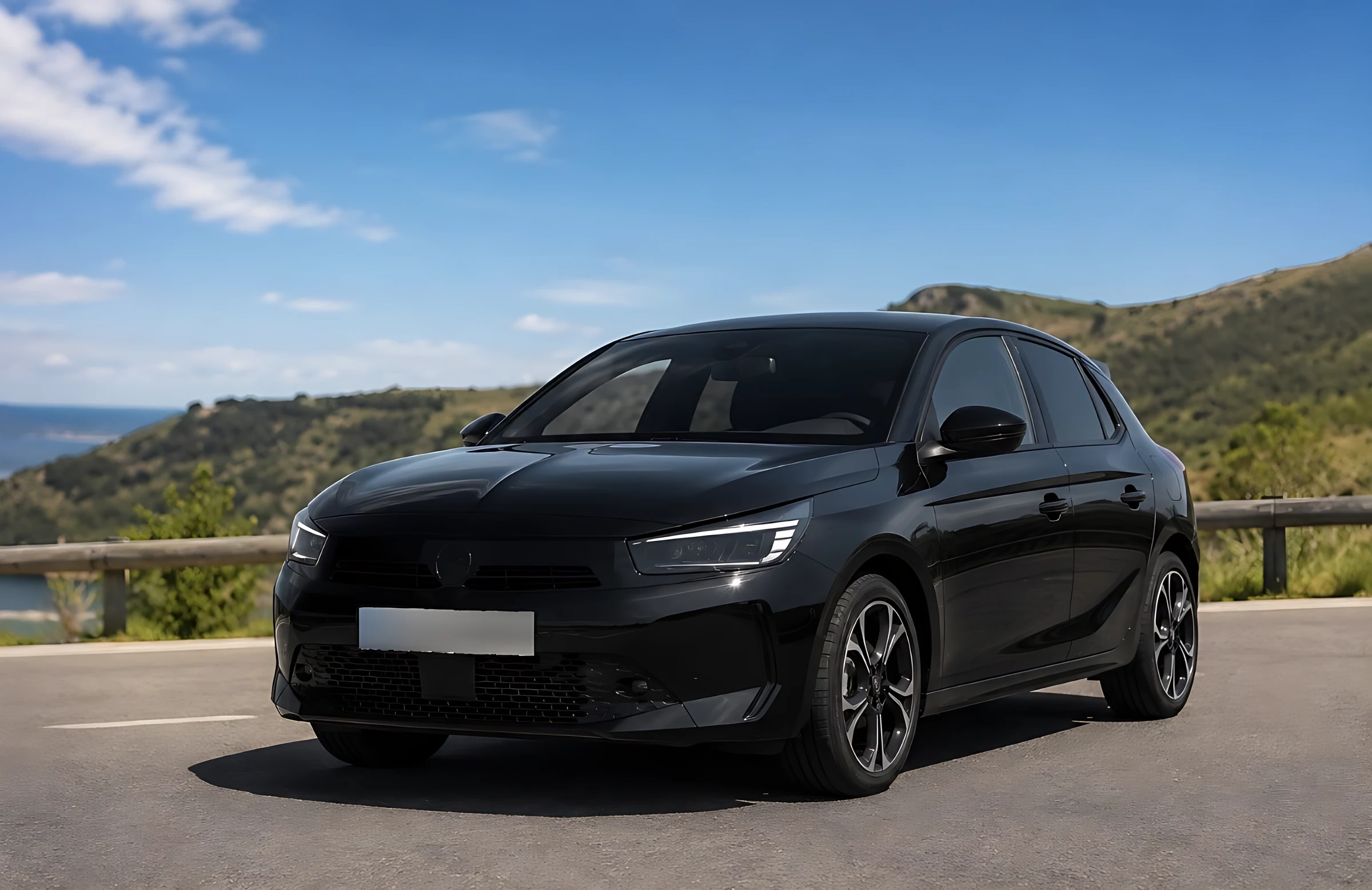 Opel Corsa GS negro aparcado en una carretera de costa con el mar al fondo